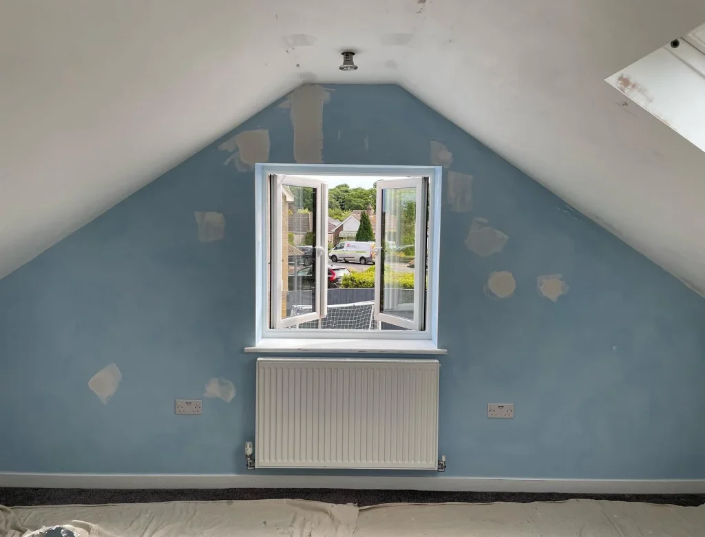 Blue wall attic room with open window.