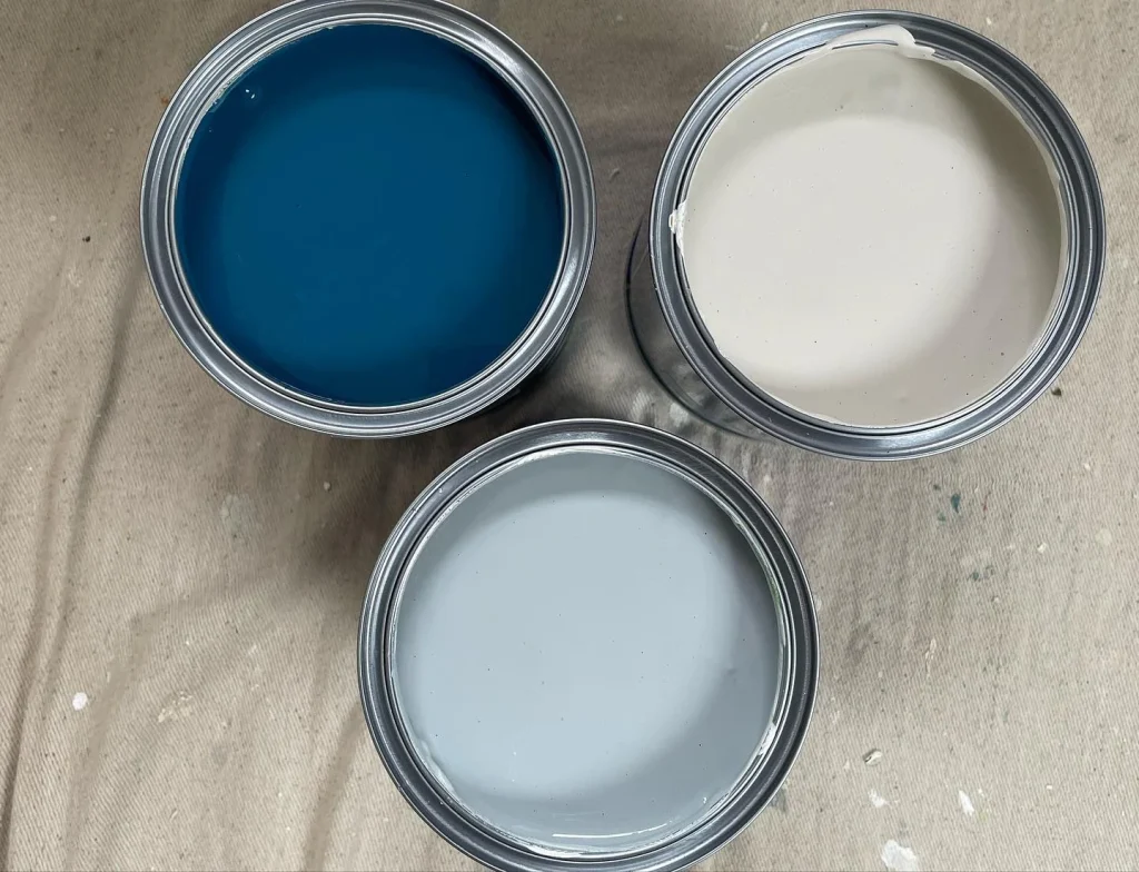 Three open cans of paint on canvas.