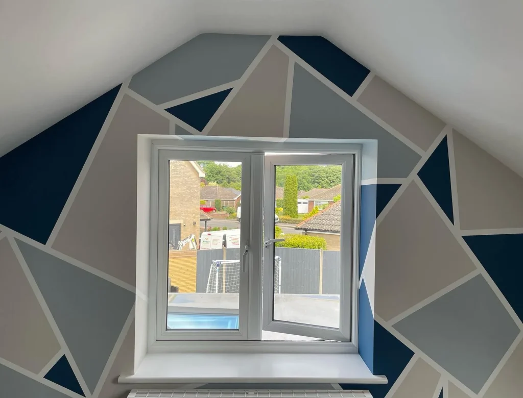 Geometric wall design with window view.