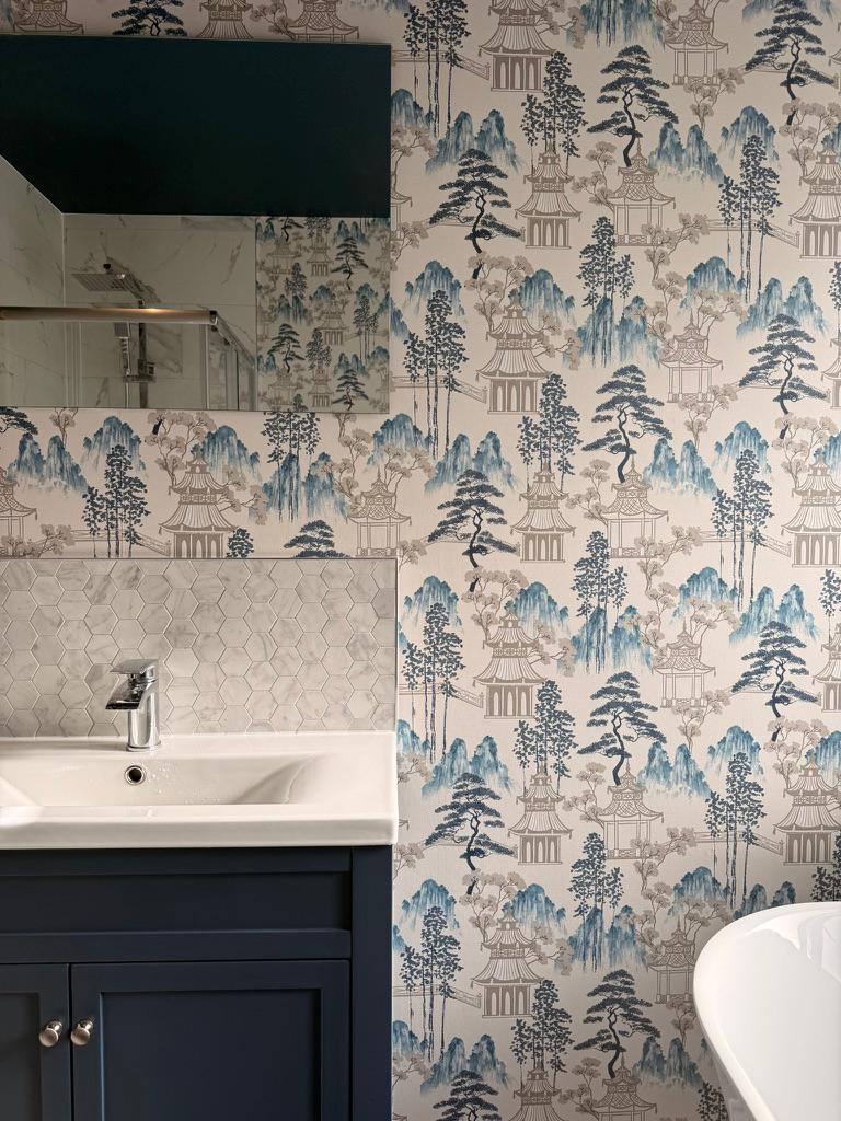 A bathroom hung with blue-and-white oriental-pattern wallpaper