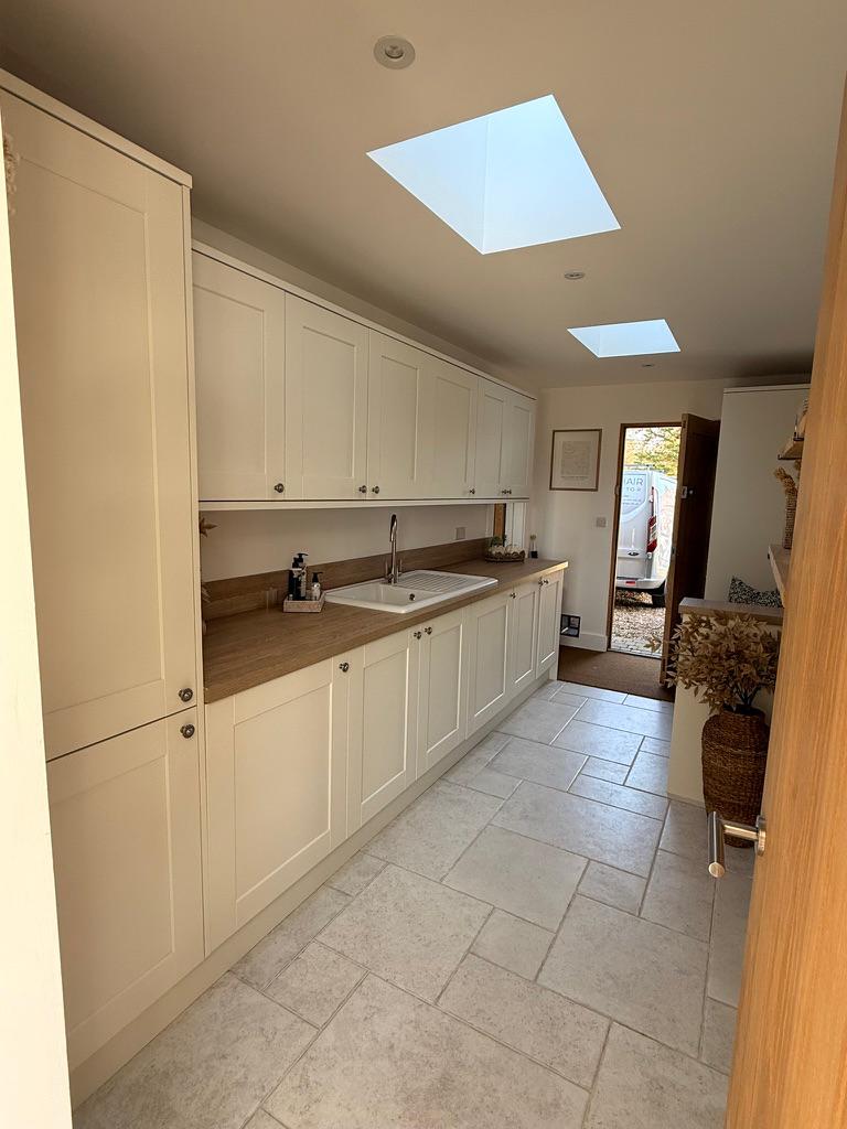 A cream shaker utility kitchen with skylights, freshly sprayed