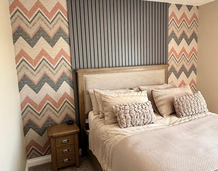 Modern bedroom with chevron wallpaper and upholstered bed