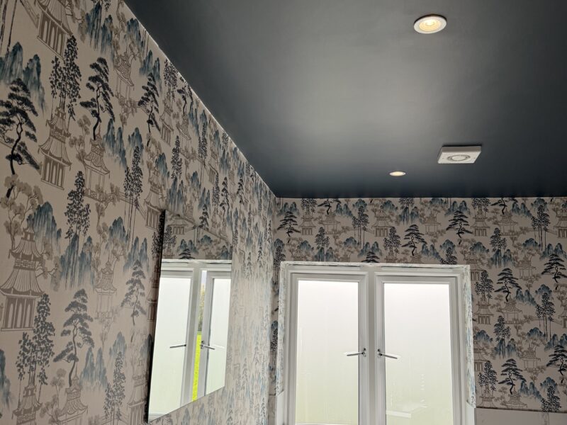 Modern bathroom with patterned wallpaper and dark ceiling