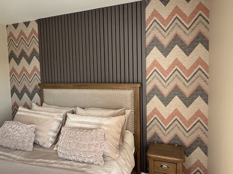 Modern bedroom with chevron wallpaper and wooden bed