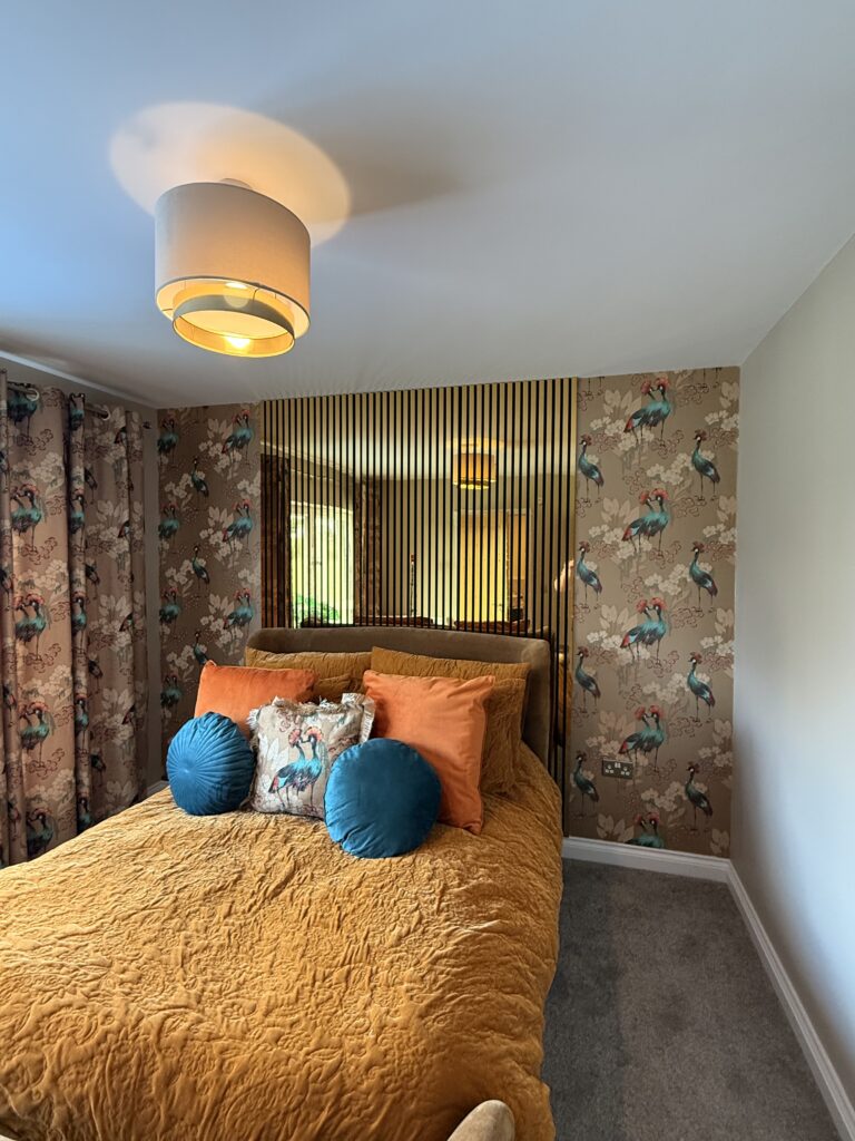 A bedroom with crane-patterned feature wallpaper