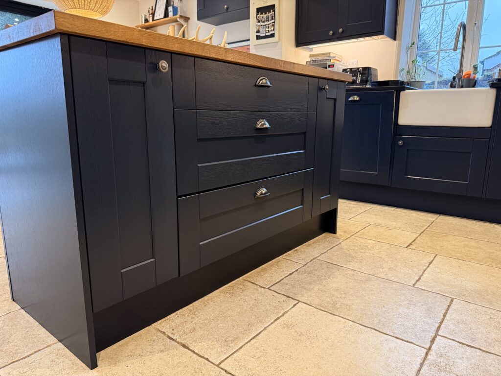Dark blue kitchen island with wooden worktop