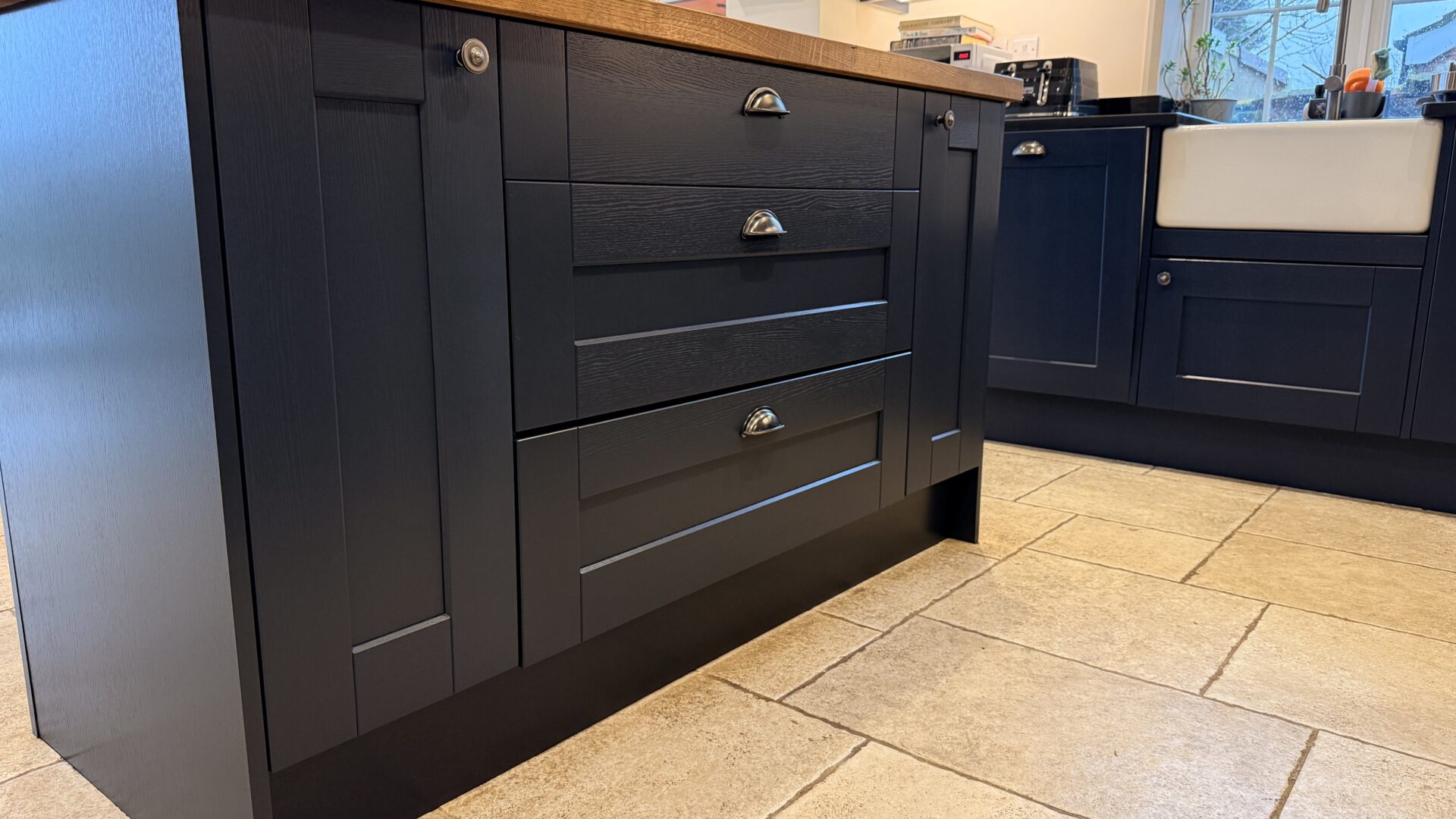 A kitchen island sprayed in dark navy with drawers