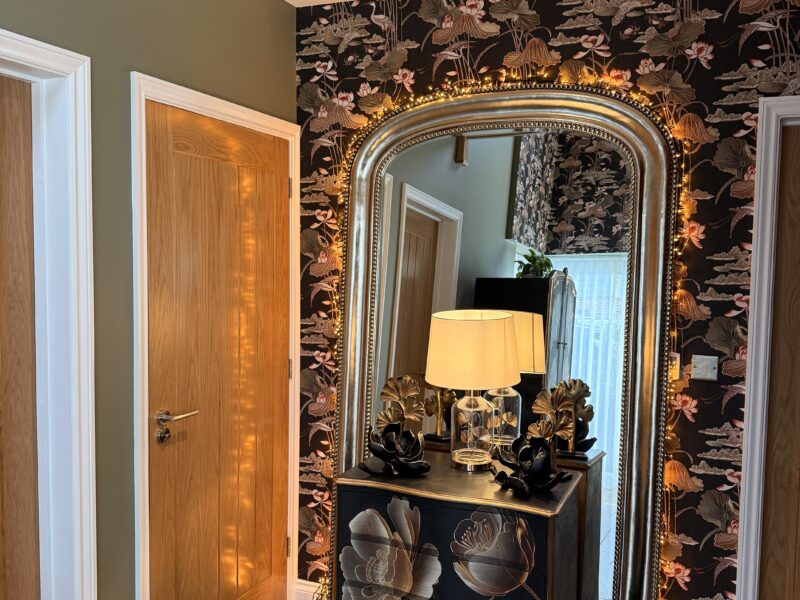 Ornate mirror and floral wallpaper in hallway