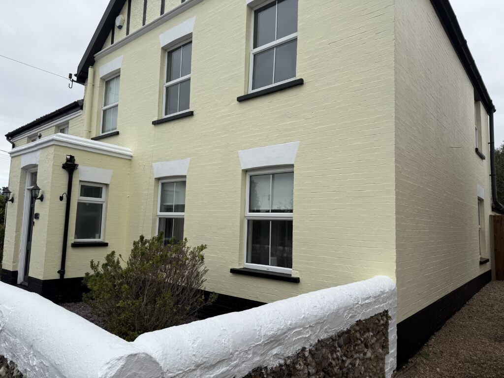 Pale yellow brick house with white trim