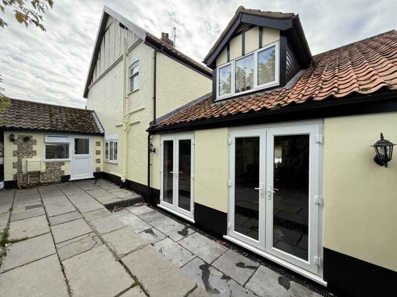Cream brick house with patio and French doors