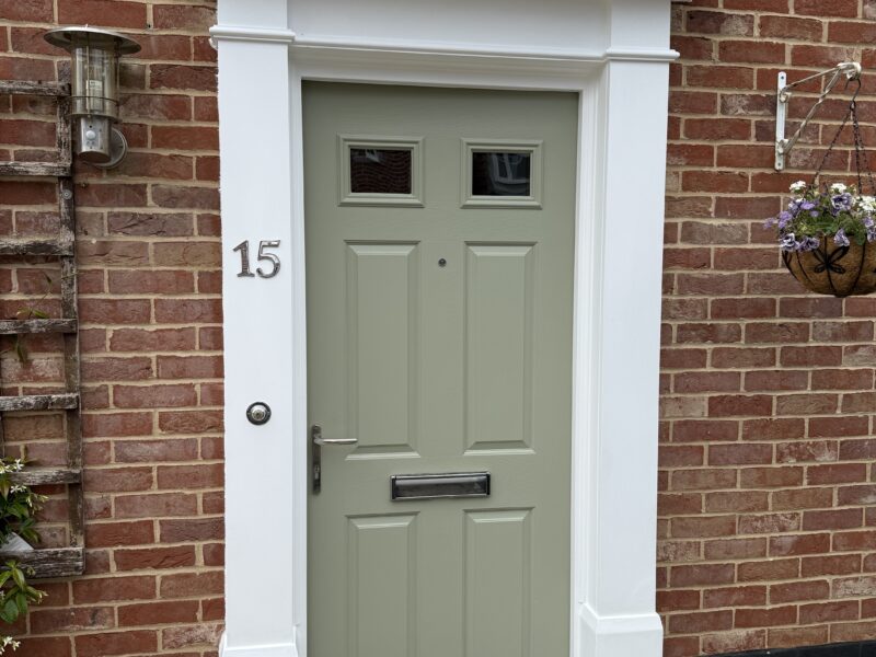 Sage green front door on red brick house