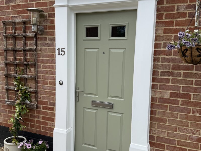 Sage green front door on brick house